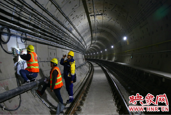 設(shè)施設(shè)備部通號室信號專業(yè)工程師正帶領(lǐng)著同事們進行軌道信號轉(zhuǎn)轍機零件更換。