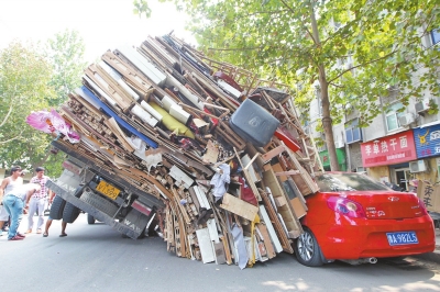 紅色小轎車被砸，卡在路邊動彈不得。