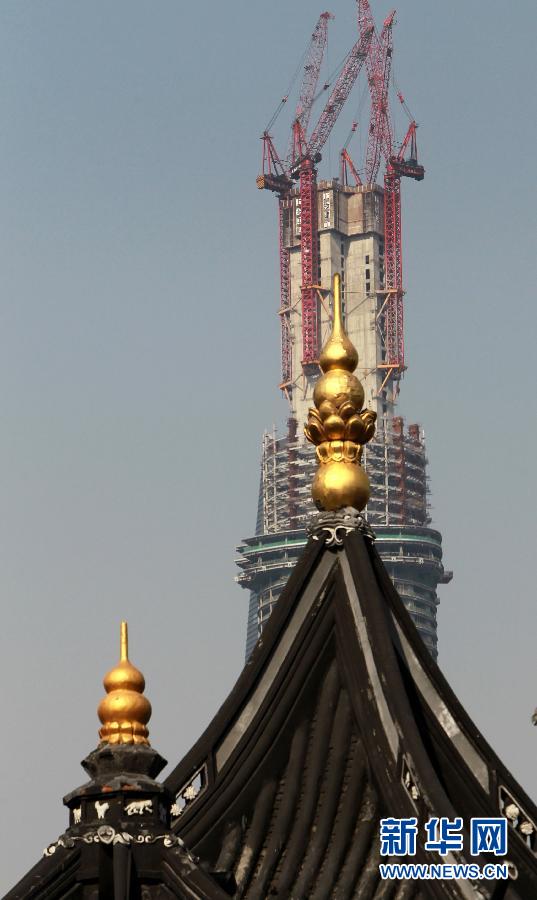 正在建設中的“上海中心”與豫園地區(qū)的傳統(tǒng)建筑（前）（4月11日攝）。
