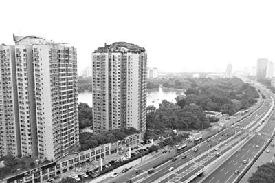 昨日，人濟山莊小區(qū)，與其他樓相比，B棟樓頂層天臺上違規(guī)建造了一棟兩層小樓，假山大樹俱全。新京報記者