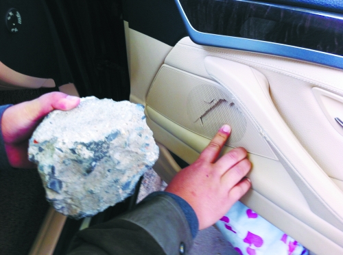 “飛”進(jìn)寶馬車內(nèi)的大石塊,將寶馬車的車門內(nèi)飾板砸爛。