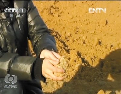 麻剛沙系麻剛石粉碎而成。記者找到一塊麻剛石，一捏就碎成粉末，硬度非常差。央視截圖