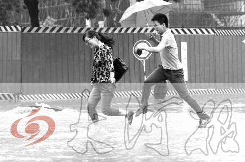 鄭州經(jīng)三路與北環(huán)交叉口處，積水較深，行人們不得不“練輕功”。 記者 白周峰 攝影