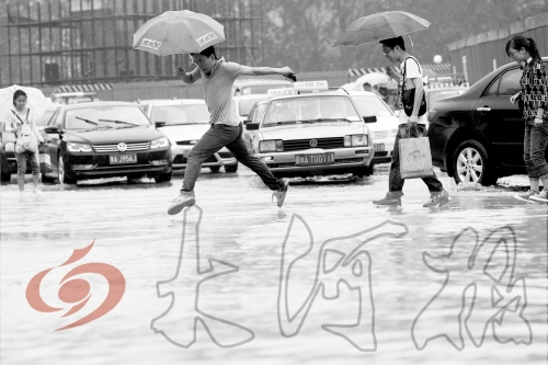 鄭州經(jīng)三路與北環(huán)交叉口處，積水較深，行人們不得不“練輕功”。 記者 白周峰 攝影