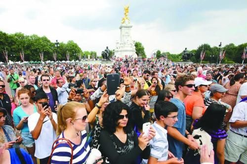 7月23日，在英國倫敦白金漢宮外，民眾們爭相閱讀“王室寶寶”出生的正式公告。