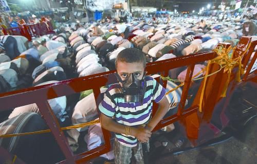 當(dāng)?shù)貢r(shí)間28日晚，在埃及開羅納賽爾城，一名小男孩頭戴防毒面具參加穆兄會(huì)的集會(huì)示威。