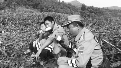 饑餓難忍，中國緊急救援河南基地的救援隊(duì)員在已毀的玉米地里撿拾生玉米吃。