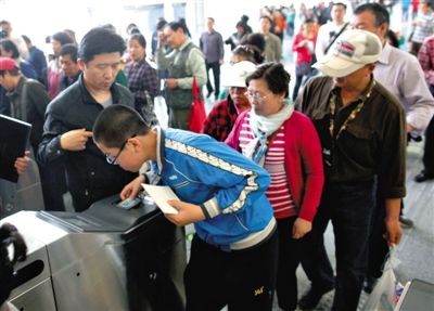 去年5月5日，14號線園博園站，乘客刷卡出地鐵。北京公交地鐵將實行計程票制，多乘坐多付費。