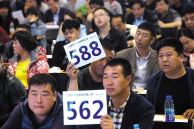 昨日，拍賣現(xiàn)場競拍者舉牌競拍。新京報(bào)記者