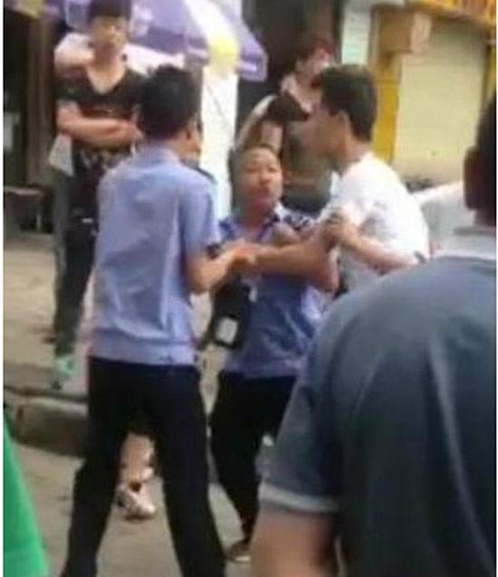 付某（右）與城管執(zhí)法人員廝打在一起。