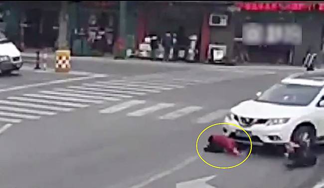 圖為小姑娘被卷進(jìn)車輪下瞬間。