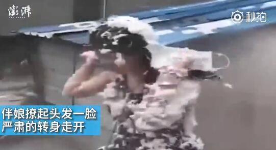 視頻中可以看到，雖然伴娘事先有穿雨衣防備，但在被伴郎團圍攻時，雨衣被拔下，更過分的是，有人還用滅火器直接對著她的臉噴。后來伴娘好像是生氣了，撩起頭發(fā)一臉嚴肅的轉(zhuǎn)身走開。