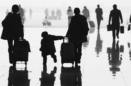 昨日，鄭州東站，一名孩子拉著媽媽和包裹快樂(lè)地奔走在春運(yùn)的途中