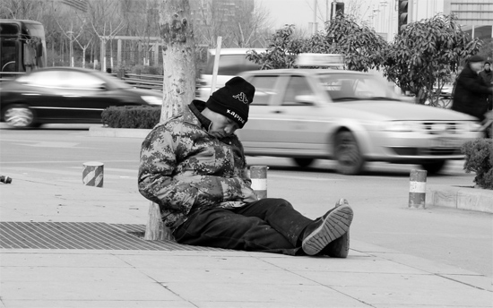 2月2日，鄭州市中州大道農業(yè)路立交橋下，50歲的王文德打算在臨近春節(jié)前再接些零活兒，由于疲憊，他睡著