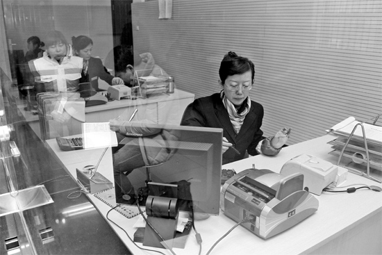 2月16日，鄭州市自來水總公司鄭東新區(qū)一營業(yè)廳，柜臺內(nèi)工作人員正在為市民辦理業(yè)務(wù)