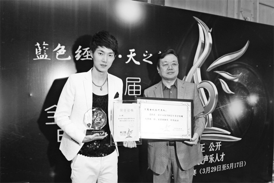 王晰領(lǐng)取流行組冠軍獎(jiǎng)，河南電視臺(tái)藝術(shù)總監(jiān)李暄代表河南電視臺(tái)領(lǐng)取第15屆青歌賽團(tuán)體獎(jiǎng)