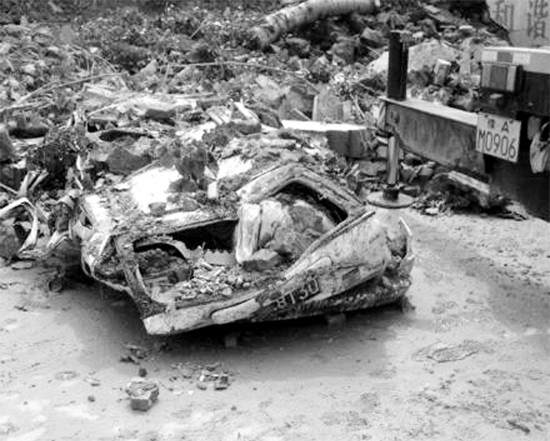 7月2日，新密市區(qū)，暴雨沖倒圍墻，一輛汽車被砸成“鐵餅”