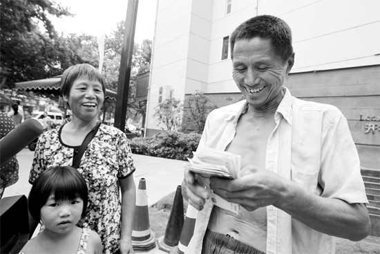 昨日，鄭州市明達(dá)路與豐慶路交叉口西300米路南，來自中牟的瓜農(nóng)拿到西瓜款，笑開顏東方今報(bào)記者袁曉強(qiáng)