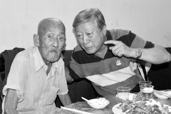 昨日，來自北京的英雄后代胡冠軍（右）專門趕到西平縣看望抗戰(zhàn)老兵孫殿修老人