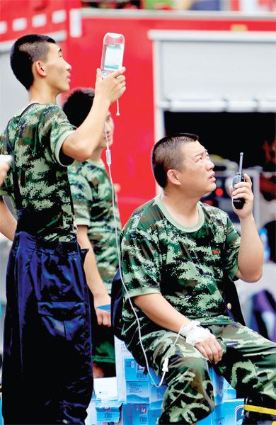 火場(chǎng)外，被消防戰(zhàn)士稱為“李大隊(duì)”的救援人員掛著吊瓶現(xiàn)場(chǎng)指揮