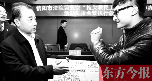 張立勇將依法執(zhí)行回來的農(nóng)民工工資發(fā)放給案件當事人游昌華，游昌華施以中國傳統(tǒng)作揖禮答謝