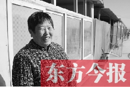 在京水村的臨時過渡區(qū)內，一位大媽在儲存大白菜