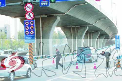 交警在東風(fēng)路從北向南上橋口處擺上反光錐，間歇放行
