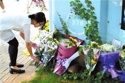 6月8日下午，記者來到廈門公交車爆炸事發(fā)現(xiàn)場橋下，附近已聚集了十幾個自發(fā)前來悼念的市民。橋墩下排放了一圈或黃或白的菊花，還有玖瑰、百合等。