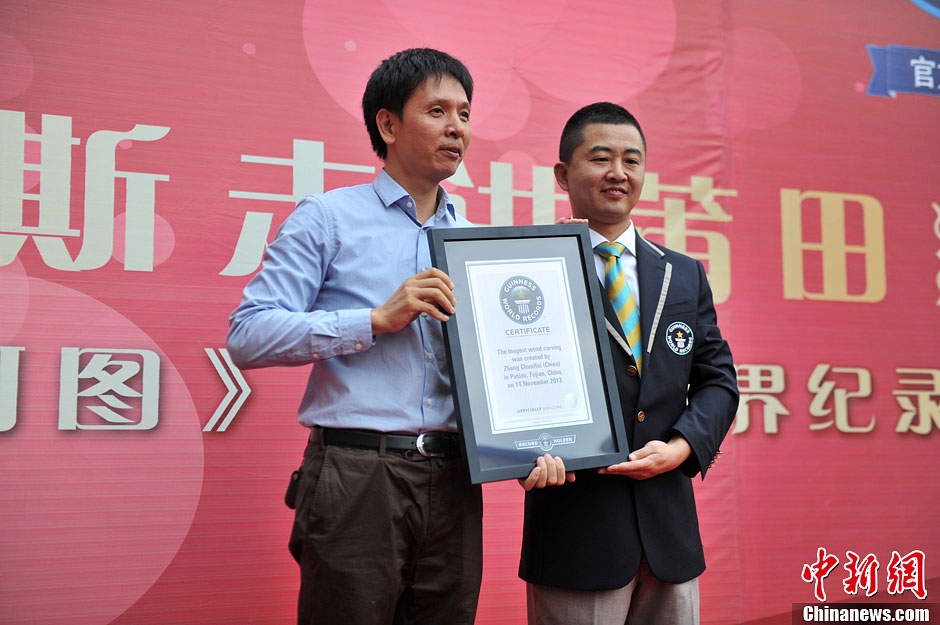 圖為世界吉尼斯認(rèn)證官為鄭春輝（左）頒發(fā)證書。呂明 攝