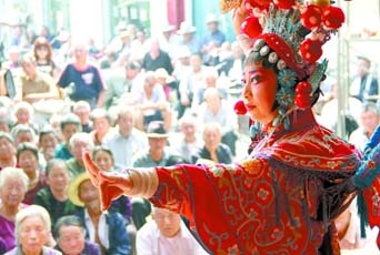 圖為8月15日戲曲演員在“流動舞臺車”上表演傳統(tǒng)地方戲《穆桂英下山》。