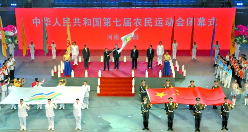 南陽市市長穆為民將農(nóng)運會會旗遞交到下一屆東道主吉林省松原市市長李相國手里。