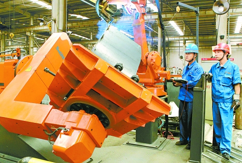 圖為龍工集團中原公司的職工正在操作機器人焊接裝載機。