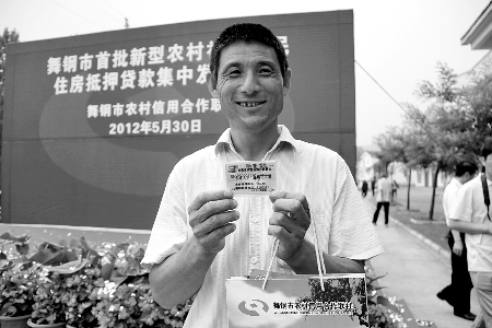 領(lǐng)到貸款，農(nóng)民開心地笑了。