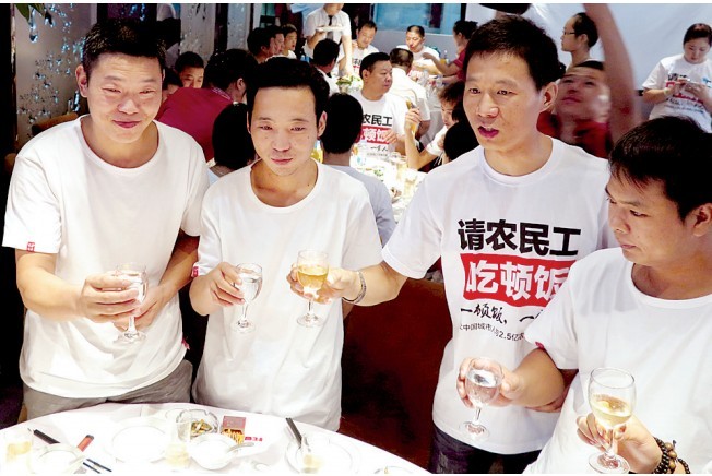 活動(dòng)發(fā)起人張楠（右二）給農(nóng)民工敬酒。