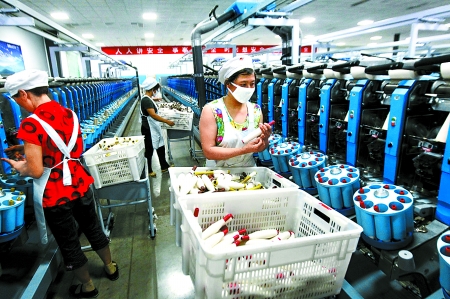 6月6日，舞鋼市鑫海紡織有限公司員工正在新建成的紡紗車間生產(chǎn)。