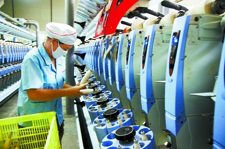 7月3日，在鄧州市永泰棉紡有限公司電腦控制全自動(dòng)紡紗車間，紡織工人正在生產(chǎn)棉紗。