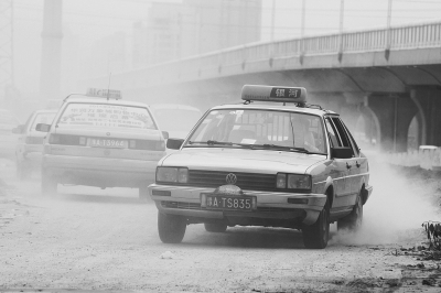 施工的道路上，車輛通過塵土飛揚。