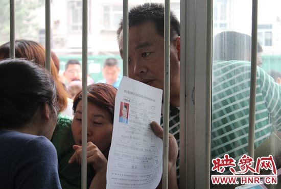 不少家長(zhǎng)擠在報(bào)名窗口前咨詢報(bào)名事宜。