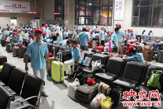 大學生志愿者在火車站候車室內(nèi)整裝待發(fā)。