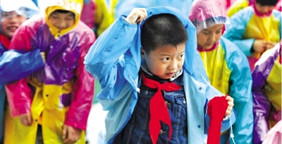 昨日下午,農(nóng)科路上一小學(xué)放學(xué)時,孩子們大部分都穿著雨披。