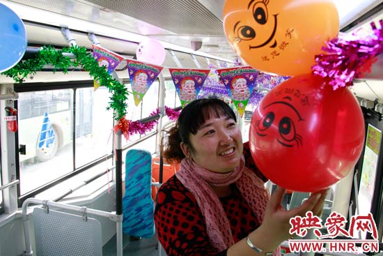 鄭州快速公交B3區(qū)間線車長李鵬云在車廂里懸掛氣球，布置圣誕車廂，營造歡樂圣誕氛圍