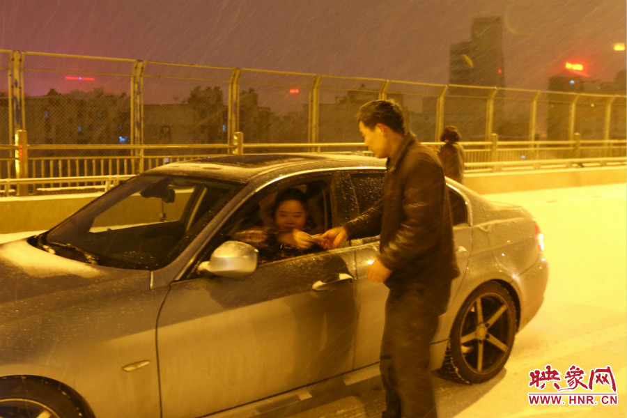 “推車人”幫助一輛車上坡后，收取“勞務(wù)費(fèi)”。