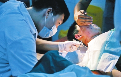 孩子身上有7道傷痕，其中兩道需要縫合，其他的均為擦傷，醫(yī)生正對(duì)他施治。