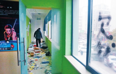 　健身會所地上一片狼藉，玻璃上噴著黑色“欠錢”二字。