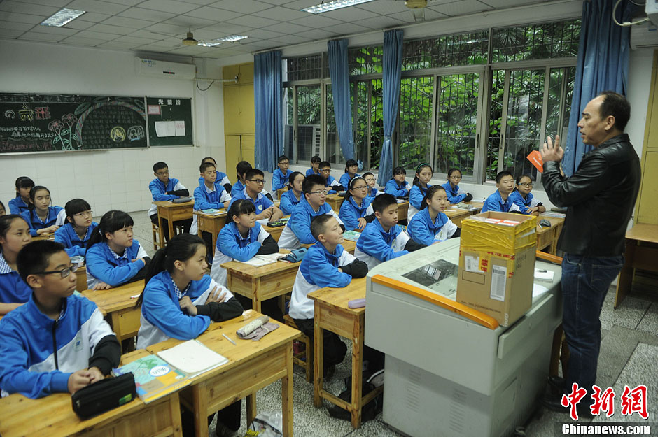 圖為老師正在向同學(xué)們講解用非智能手機對他們的好處。