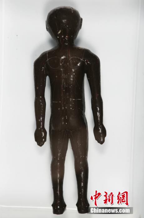 圖為出土的人體經(jīng)穴漆俑。