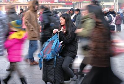 春運(yùn)首日，北京站客流量明顯增多，一名女孩在人流中等待進(jìn)站。