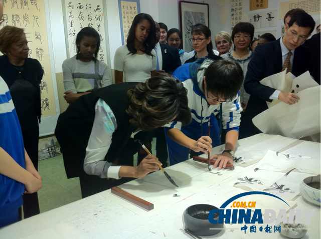 　北京時(shí)間3月21日，美國第一夫人米歇爾參觀北師大二附中時(shí)，與學(xué)生一起練習(xí)書法。
