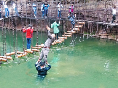 中年男游客正踩著景區(qū)安全員郭小明的肩膀過河。網(wǎng)友“@我的小名叫張孩”供圖