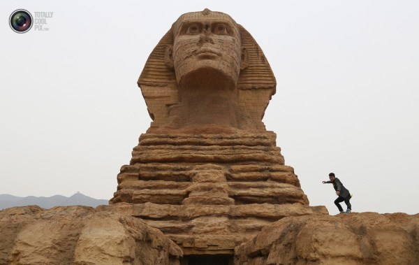 石家莊郊外，一名男子與山寨版獅身人面像合影留念。